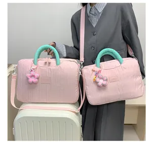 Detailed view of the trendy pink laptop tote bag with a green handle and flower charm.