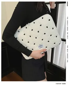Detailansicht der gesteppten Laptoptasche mit schwarzer Herzstickung und sicherem Reißverschluss.