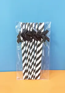 Cannucce di carta a strisce bianche e nere con fiocchi neri per decorazioni di feste.