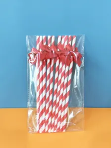Cannucce di carta a righe rosse e bianche con fiocchi rossi per decorazione festa.