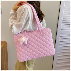 Detail shot showing the pink quilted laptop bag with a cute plush star charm pendant.