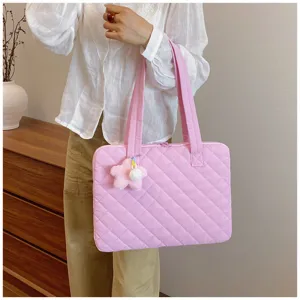 Close-up detail of the pink quilted laptop bag with cute star plush pendant and tote handle.
