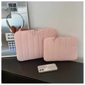 Pink quilted laptop sleeve detail, soft fabric texture with double zipper closure setup.