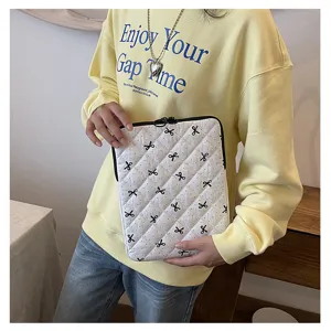 Custodia per laptop trapuntata bianca con grazioso motivo a fiocco nero, borsa protettiva morbida.