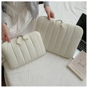 Close up of quilted laptop sleeve with striped design, soft white fabric and dual zipper.