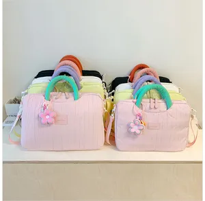 Close-up view of stylish colorful laptop tote bags stacked neatly on a wooden desktop.