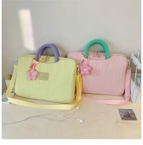 Detailed shot of pastel pleated laptop tote bags with cute flower charms and comfortable handles.