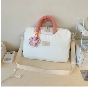 White quilted laptop bag detail with pink handle, colorful flower pendant, and adjustable strap.