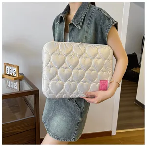Detailaufnahme der gesteppten Laptoptasche mit süßem Herzmuster und Etikett, leichtgewichtig.
