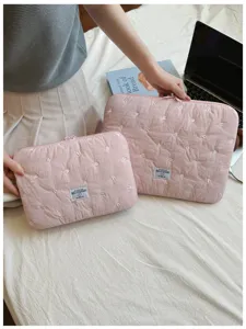 Detailansicht der rosa gesteppten Laptoptasche mit feiner weißer Bestickung und Stoffetikett.