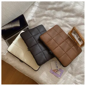 Detailed view of quilted laptop sleeve in soft padded material, minimalist daily solid color.