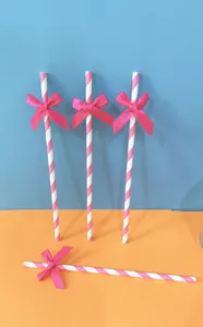 Cannucce di carta a strisce rosa e bianche con fiocco per decorazione festa e tavolo.