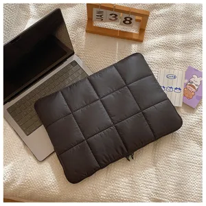 Detail shot of black quilted laptop sleeve, minimalist down-feel padded notebook storage case.