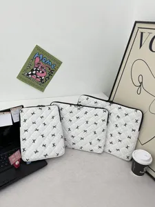 Custodia trapuntata bianca per laptop con fiocco nero, elegante protezione per tablet e notebook.