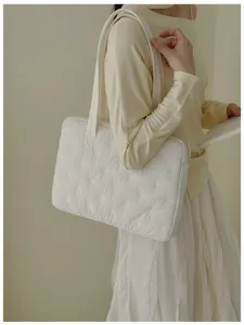 Vue détaillée du sac cabas matelassé blanc brodé de nœuds pour ordinateur portable de 14 pouces.