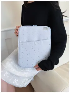 Dettaglio di una custodia per laptop azzurro chiaro con stelle, tasca frontale e cerniera.