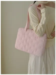 Gros plan sur le sac pour ordinateur matelassé rose mignon avec broderie de nœuds, idéal au quotidien.
