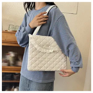 Detail view of the floral quilted tablet bag featuring cute lace ruffles and a convenient shoulder strap.