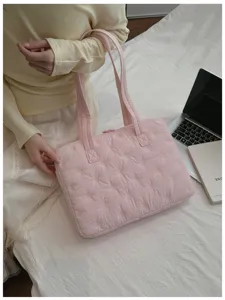 Vue détaillée du sac cabas pour ordinateur matelassé rose avec jolis nœuds brodés.