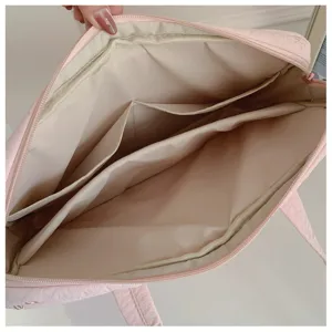 Sac pour ordinateur matelassé rose avec nœud brodé, compartiments multiples pour ordinateurs.