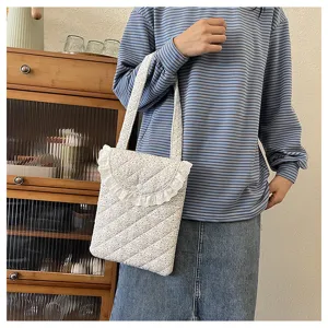 Floral quilted shoulder bag with delicate white lace trim, casual daily lifestyle accessory.
