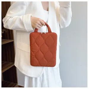 Detailed shot of a stylish orange quilted laptop bag with handle, Korean style notebook sleeve.