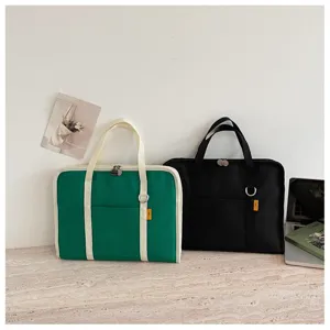 Dettaglio borsa per laptop in tela minimalista con cuciture pulite e tasca frontale.