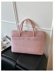 Pink quilted laptop bag detail shot showcasing soft fabric, dual handles and secure zipper.