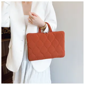 Quilted laptop sleeve detail view, stylish rust orange notebook carrying case with soft handle.
