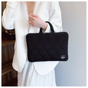 Detailed view of black quilted laptop sleeve with handle, Korean style lightweight notebook bag.