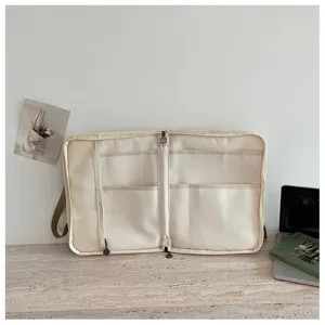 Dettaglio dell'interno della borsa per laptop in tela beige con scomparti e tasca in rete.