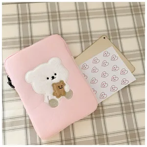 Detail shot of the cute pink plush tablet sleeve with lovely bear embroidery design details.