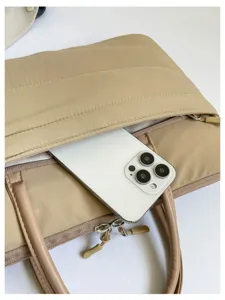 Detail view of Korean style quilted laptop bag, soft beige handle and zipper pocket.