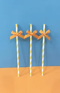 Cannucce di carta a righe con fiocchi arancioni, perfette per feste e tavoli da dessert.