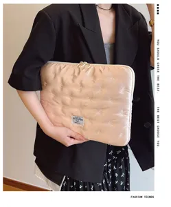 Detailed view of quilted satin laptop sleeve with cute embroidered bows and fabric label.