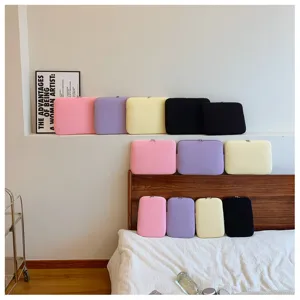 Detailansicht einfarbiger Laptopschutzhüllen in Pastellfarben gemütlich im Zimmer arrangiert.