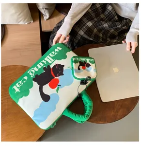 Detail view of cute green laptop sleeve with black cat print and matching pouch, cozy lifestyle.