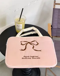 Niedliche rosa gesteppte Laptoptasche mit brauner gestickter Schleife und inspirierendem Text.