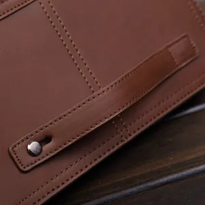 Bolso de mano de cuero marrón para hombre vista detallada con costuras finas y estilo.