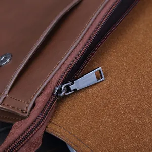 Primer plano detallado de bolso de mano vintage de cuero marrón para hombre con cremallera.