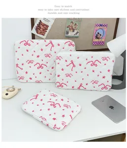 Detailed view of white quilted laptop sleeve with cute pink bow and star embroidery patterns.