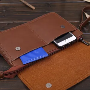 Vista detallada del bolso de mano de cuero marrón para hombre, mostrando el bolsillo.