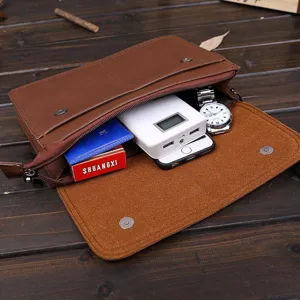 Detalle de bolso de mano de cuero marrón retro para hombres que muestra la capacidad interior.