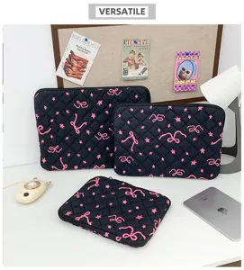 Detailed view of black quilted laptop sleeve featuring cute pink embroidered bows and stars.