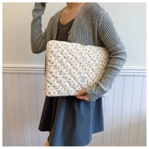 Nahaufnahme einer gesteppten Laptoptasche mit Blumenmuster, weich und gepolstert für Tablets.