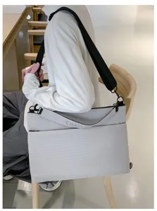 Vue détaillée du sac bandoulière pour ordinateur portable gris avec sangle.
