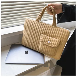 Detailed view of the quilted khaki laptop sleeve featuring a handy front pocket and handles.
