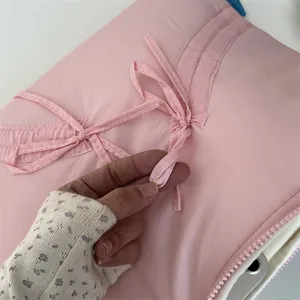 Nahaufnahme der süßen rosa Laptoptasche mit hübschen Schleifendetails und Reißverschluss.