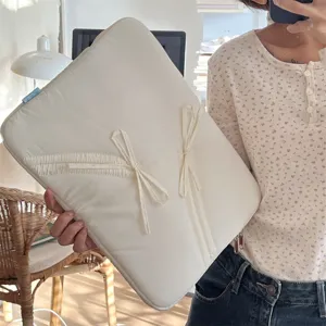 Detailansicht der cremeweißen 13-Zoll Laptoptasche mit süßem Schleifen-Design und weichem Schutz.