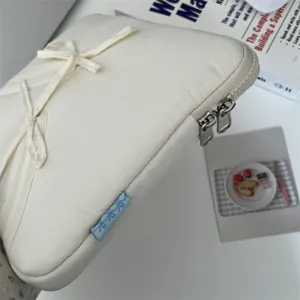 Detailaufnahme der weißen Laptoptasche mit süßem Schleifenband und sicherem Reißverschluss.